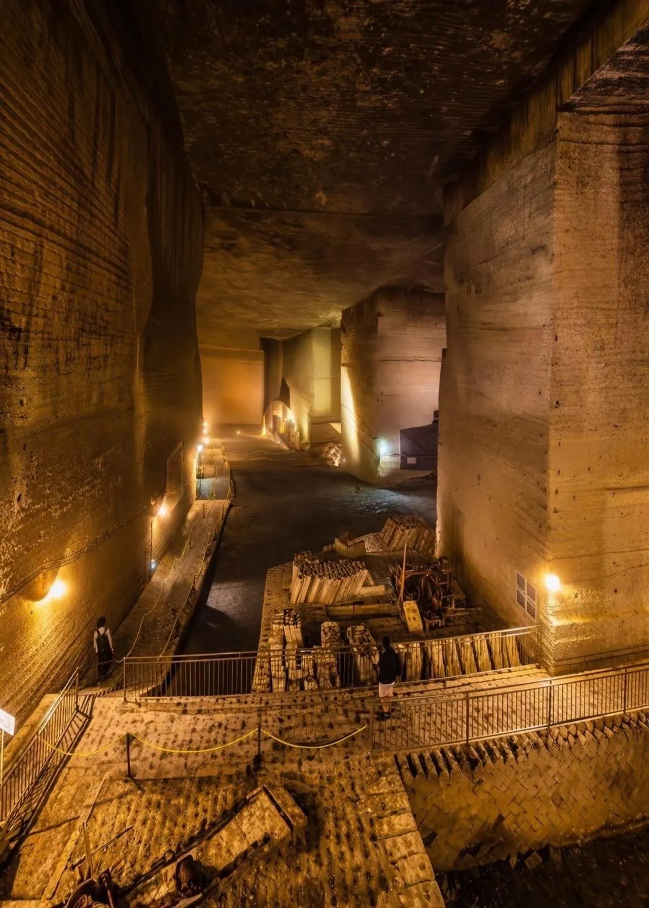 The vast underground hall of the Oya stone quarry, lit in warm light