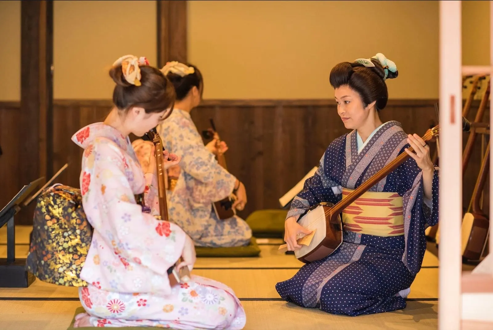 Performers playing shamisen on tatami